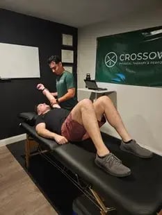 physical therapist guiding athlete through strength exercise on force plate